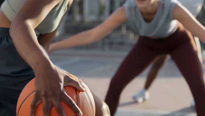 side view female friends playing basketball 1